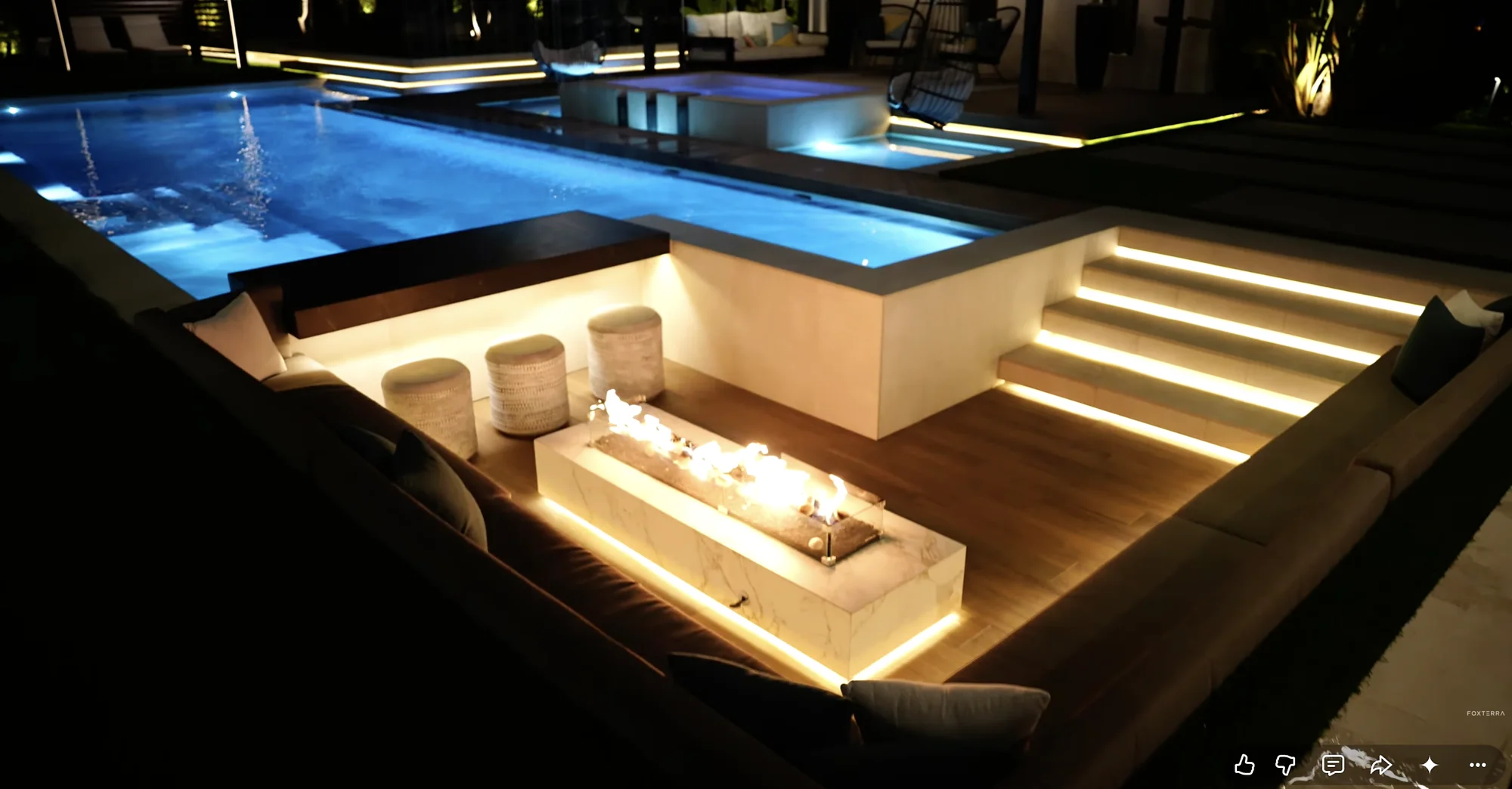 Pool with a sunken fire lounge at night